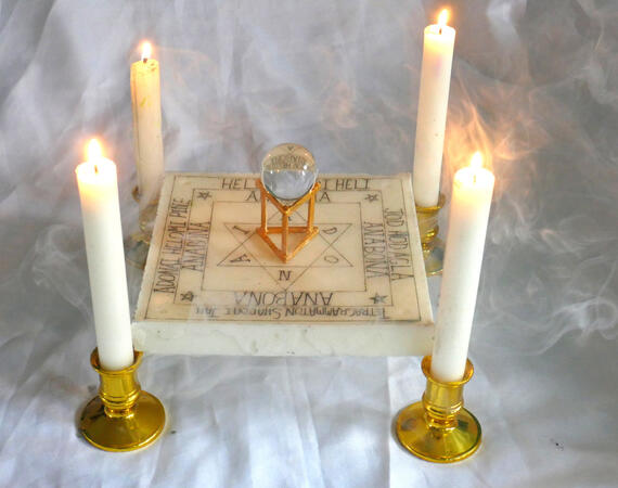 Four-candle ritual arrangement with a crystal sphere and inscribed tablet Four-candle ritual arrangement with a crystal sphere and inscribed tablet